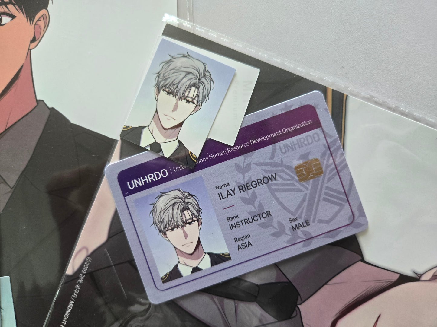 Close up of Passion merchandise featuring Ilay Riegrow UNIDRO ID card and his ID photos
