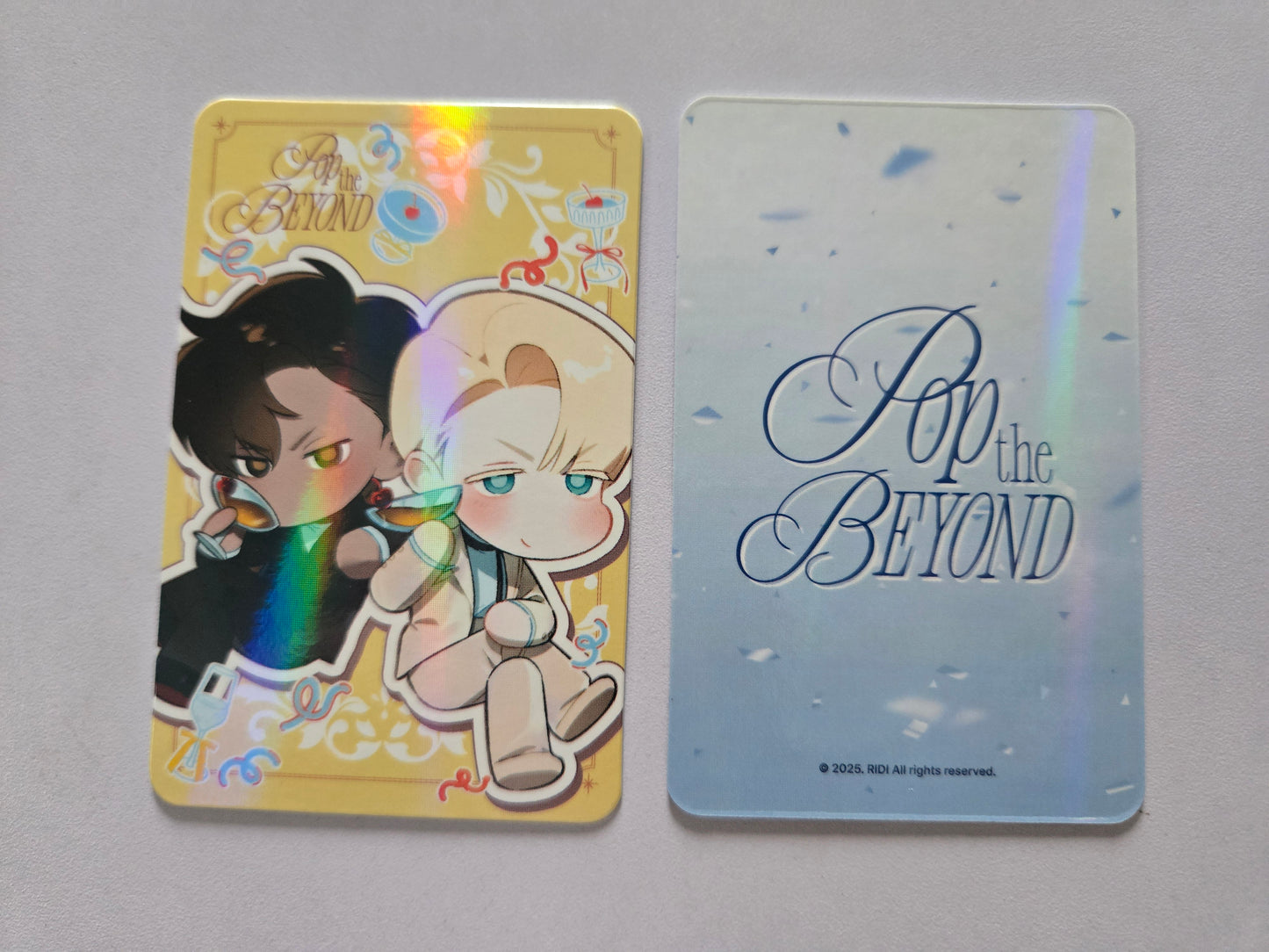 Codename Anastasia Chibi yellow photocard on the left. The right card features pop the beyond text