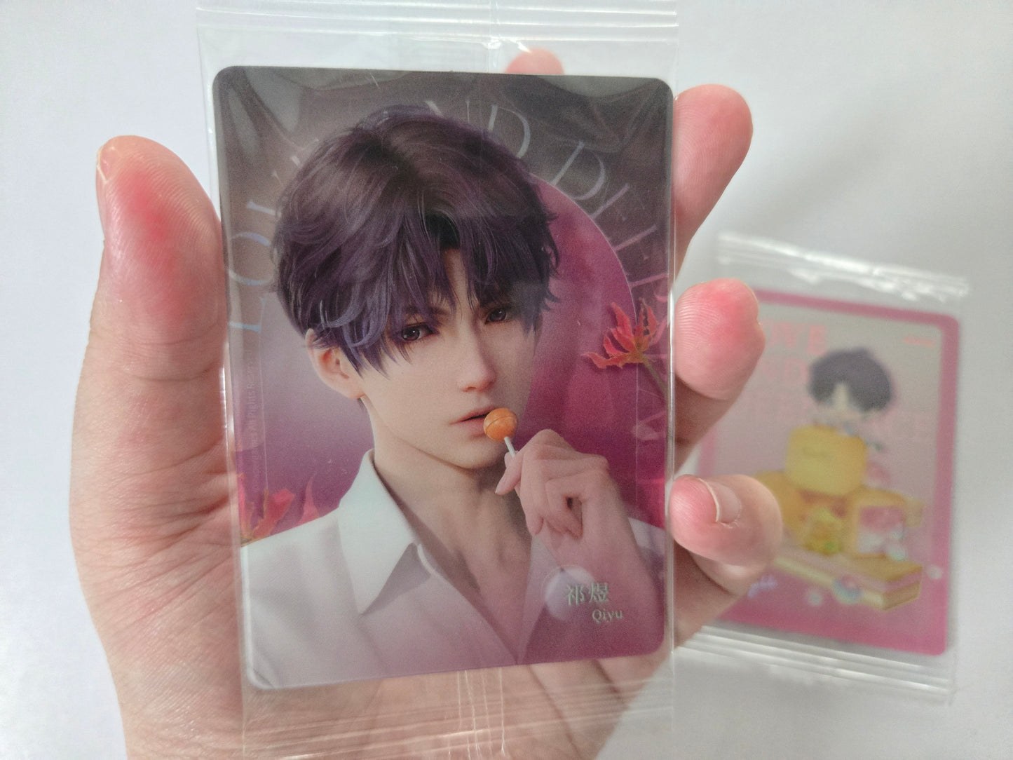 祁煜 with purple hair and a white shirt against a pink background