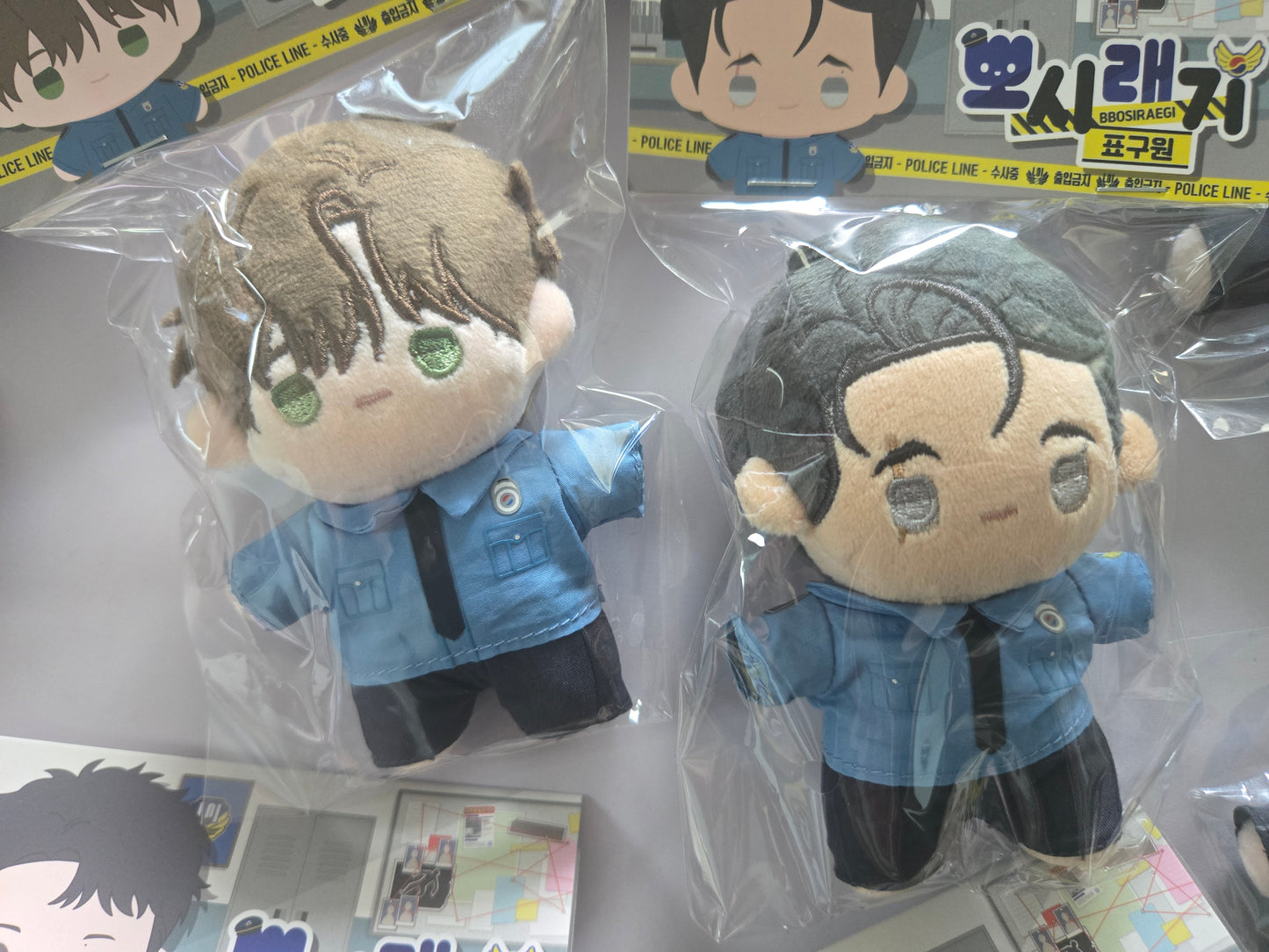 The Hounds of Sisyphus plush dolls in retail packaging, featuring Guwon and Jinwoo