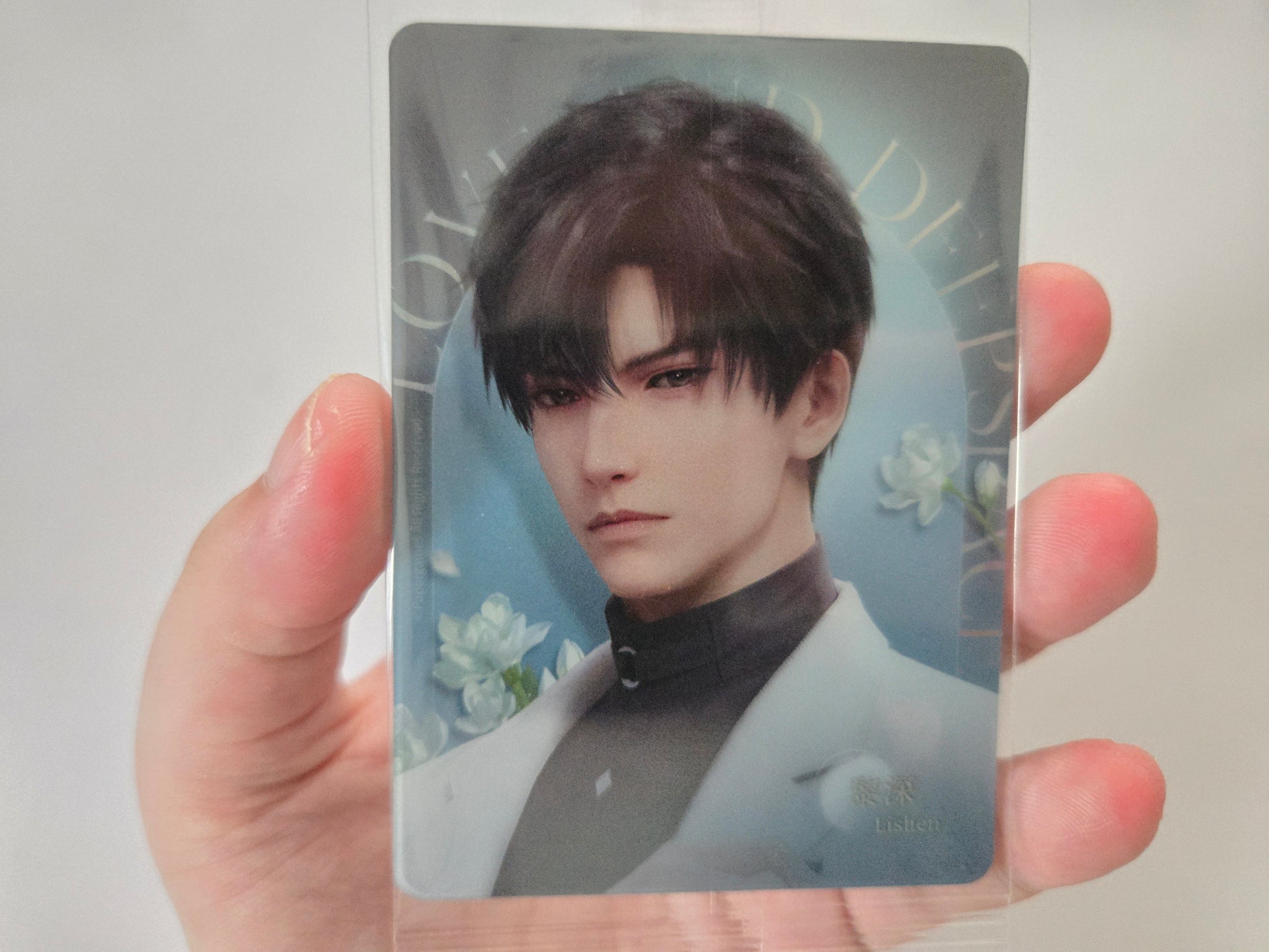 Zayne from Love and Deepspace with dark hair, wearing a white jacket over a dark shirt against a soft blue floral background.
